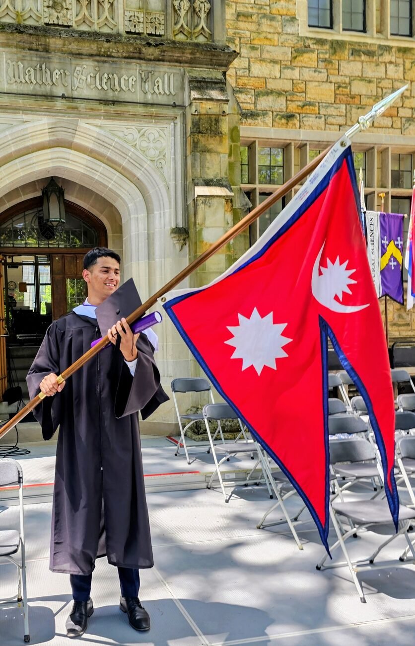 Asmod Khakurel with the Nepal flag at his Kenyon College graduation